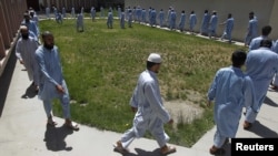 Inmates exercise around a garden at a facility in Kabul of the Afghan National Directorate of Security where would-be suicide bombers are held.