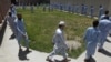 Inmates exercise around a garden at a facility in Kabul of the Afghan National Directorate of Security where would-be suicide bombers are held.