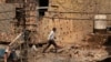A man walks on May 10 amid debris of a building reportedly damaged following a Pakistani military operation in India-administered Kashmir.