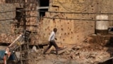 A man walks on May 10 amid debris of a building reportedly damaged following a Pakistani military operation in India-administered Kashmir.
