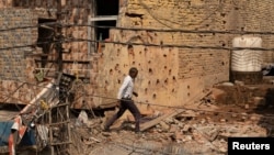 A man walks on May 10 amid debris of a building reportedly damaged following a Pakistani military operation in India-administered Kashmir.