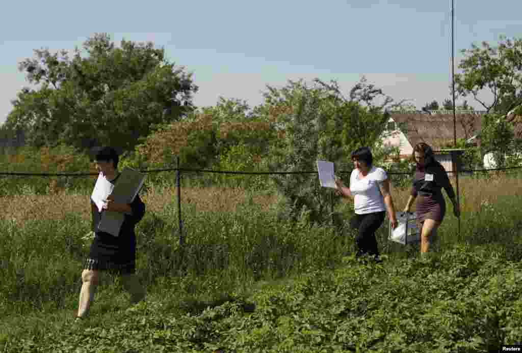 Members of the election commission carry a mobile ballot box in the village of Kornyn in the Zhytomyr region.