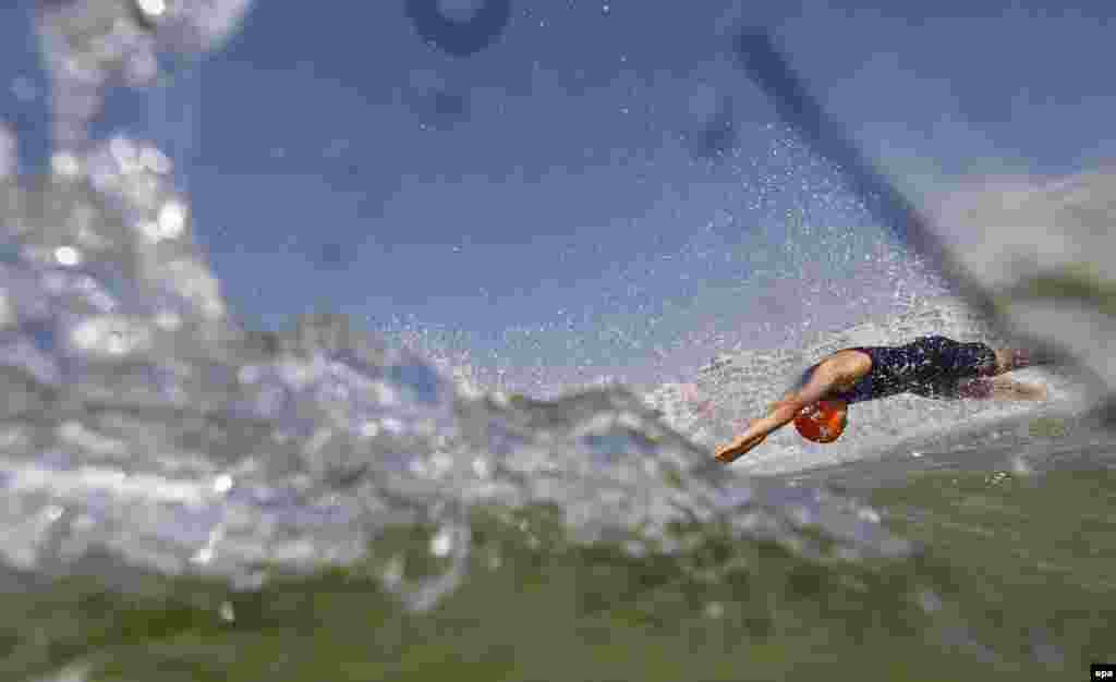 Luis Vincent of France dives into the water at the start of the men&#39;s triathlon.