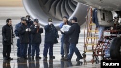 Эксперты несут в руках батарею самолета Boeing 787 Dreamliner, совершившего аварийную посадку. Такамацу, 17 января 2013 года. Фото с сайта агентства Рейтер. 