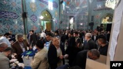 Iranian men cast their ballots at a polling station in Tehran on February 26, 2016. Iranians voted across the country in elections billed by president Rouhani as vital for curbing conservative dominance in parliament.