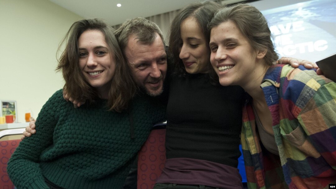 Four Greenpeace International activists show their relief following a decision by the Russian parliament adopting an amnesty ending legal proceedings against them in St. Petersburg on December 18.