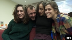 Four Greenpeace International activists show their relief following a decision by the Russian parliament adopting an amnesty ending legal proceedings against them in St. Petersburg on December 18.