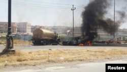 Горящая техника иракских сил безопасности в городе Мосул, 10 июня 2014.