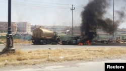 Burning vehicles belonging to Iraqi security forces are seen during clashes between Iraqi security forces and Al Qaeda-linked Islamic State in Iraq and the Levant (ISIL) in the northern Iraqi city of Mosul on June 10. 