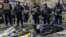 Police officers stand next to the bodies of people found under the debris of an apartment building that was hit by a Russian air strike in Kharkiv on October 31.