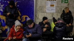 Oamenii se adăpostesc într-o stație de metrou în timpul unei alerte de raid aerian la Kiev. 8 ianuarie, 2024.