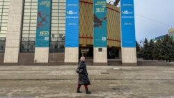 Қазақстан Конституциясын өзгерту жөніндегі референдум жарнамасы ілінген ғимараттың  қасынан өтіп бара жатқан адам. Орал, 11 наурыз, 2026 жыл.