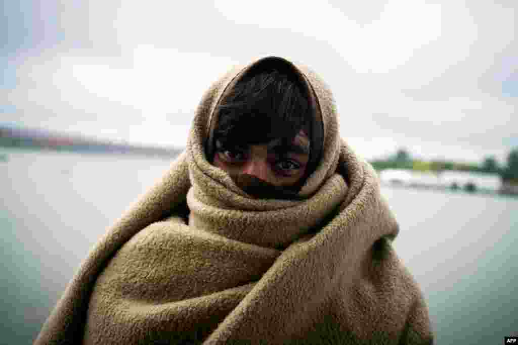 A migrant poses for a photograph while wrapped in a blanket as he shelters under a bridge in Belgrade, Serbia, on June 24. (AFP/Andrej Isakovic)