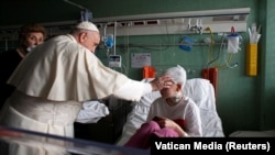 Pope Francis blesses an injured child who fled the Russian invasion of Ukraine during a visit to a children's hospital in Rome on March 19.