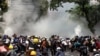 A rendőrség könnygázzal támadja a katonai puccs ellen tüntetőket Mandalajban, 2021. március 3-án.