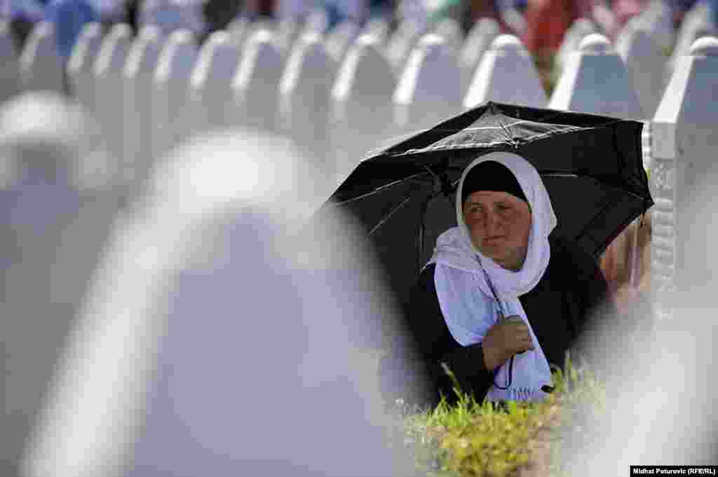 Një grua vajton më 11 korrik në Potocari, në memorialin për viktimat e masakrës së vitit 1995 në Srebrenicë, Bosnjë dhe Hercegovinë. Gjatë luftës 1992-95 në Bosnjë, Kombet e Bashkuara e lanë mënjanë Srebrenicën si vend të sigurt për civilët. Por, më 11 korrik 1995, trupat e serbëve të Bosnjës hyn në këtë qytet dhe vranë rreth 8,000 burra dhe djemë myslimanë ditën në vijim. (Midhat Poturovic, RFE/RL)