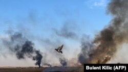 Дым над городком на сирийско-турецкой границе после удара, нанесенного на второй день после начала турецкой операции в Сирии. 10 октября 2019 года.