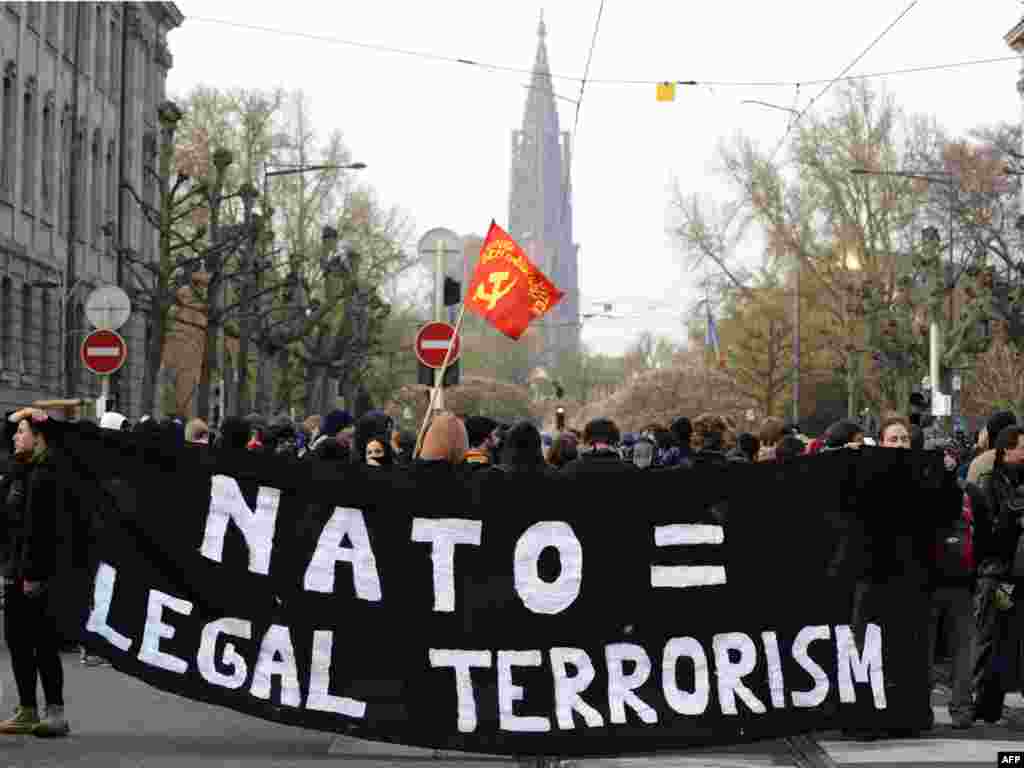 Анти НАТО протести во Стразбур - FRANCE, Strasbourg : An Anti-NATO protester holds up a banner reading 'NATO= legal terrorism' in front of riot police during a demonstration on April 4, 2009 in Strasbourg. The NATO summit, which marks the organisation's 60th anniversary, is taking place on April 3 and 4, 2009 in Strasbourg and the neighbouring German cities of Baden-Baden and Kehl. AFP PHOTO/DDP/Axel Schmidt 