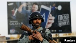 An Afghan policeman stands guard at the site of a bomb attack in Kabul on May 19.