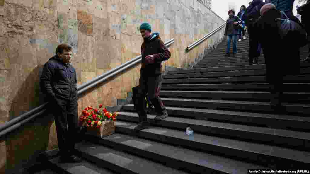 Чалавек прадае кветкі на станцыі мэтро ў Кіеве.