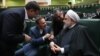 حسن روحانی در حال گفت‌وگو با دو تن از نمایندگان مجلس در جلسه ارائه بودجه ۹۹