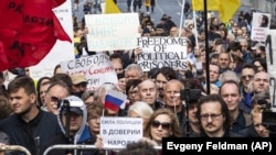 Protesters hold posters depicting political prisoners during an opposition rally in Moscow on June 10.