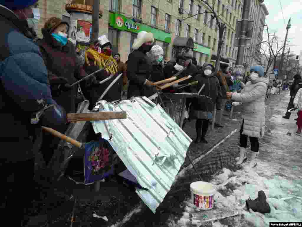 Protesters beat scraps of metal to make a raucous noise. 