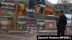 Прохожий смотрит на картины на Арбате. Алматы, март 2013 года.