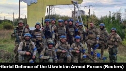 Ukrainian soldiers pose in the recently liberated settlement of Shevchenkove in Ukraine's Kharkiv region on September 10.