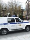 Полицейская машина около пикетчика в поддержку Абдулмумина Гаджиева. Махачкала, 7 декабря