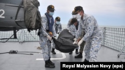 Malaysia -- Royal Malaysian Navy personnel carry a body onto their ship during a search and rescue operation for survivors of the USS John McCain ship collision in Malaysian waters, August 22, 2017