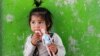 An internally displaced Afghan girl plays outside her shelter in Kabul in May.