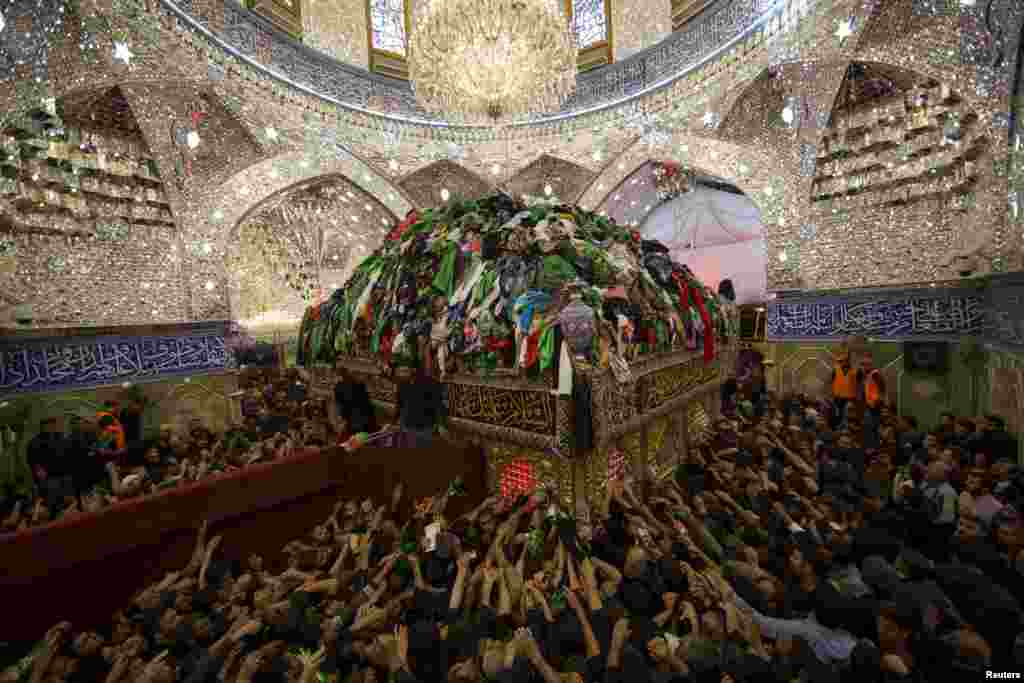 Shi'ite Muslim pilgrims reach out to touch the tomb of Imam al-Abbas located inside the Imam al-Abbas shrine to mark Arbain in the holy city of Karbala on December 3. (Reuters/Ahmad al-Husseini)