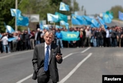 Мустафа Джемилев, стоящий с украинской стороны фактической границы, на въезде в Крым, где его пытались встретить сотни его соотечественников. 3 мая