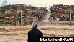 IRAN -- A man watches as floodwaters hit the city of Khorramabad in the western province of Lorestan, April 1, 2019