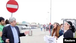 Ramin Mehmanparast, Iranian ambassador to Poland and Lithuania, reacts as women protest for Iranian women's rights to enter stadiums in Iran.