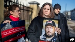 Svetlana Tihanovskaia (în centru) ține un portret al soțului ei întemnițat, la un protest în fața ambasadei R. Belarus din Lituania, pe 8 martie 2024, cerând eliberarea deținuților politici. 