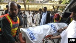 Rescue workers move a body at a hospital after a suicide bomb blast in Rawalpindi.