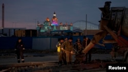 A Russian traffic officer watches construction workers near the main Olympic park in Sochi on January 7.