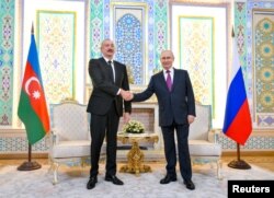 Președintele rus Vladimir Putin dă mâna cu președintele azer Ilham Aliyev în timpul unei întâlniri la Dușanbe, Tadjikistan, 9 octombrie 2025