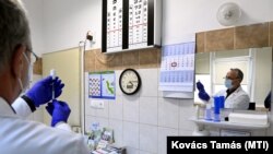Plavecz János háziorvos oltáshoz készíti elő a vakcinát tatabányai rendelőjében 2021. március 17-én.