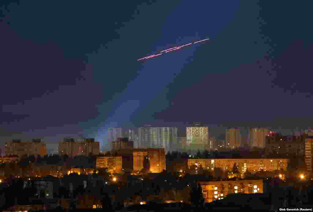 Tracers are seen in the night sky as Ukrainian soldiers fire at a drone during a Russian strike on Kyiv.