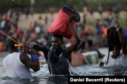 Мигранты из Гаити переходят пограничную реку Рио Браво, разделяющую Мексику и США