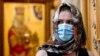 GEORGIA -- A Georgian Orthodox believer wearing a face mask attends a service celebrating Trinity Sunday in the Holy Trinity Cathedral in Tbilisi on June 7, 2020, as the country eases measures taken to curb the spread of the COVID-19 pandemic, caused by t