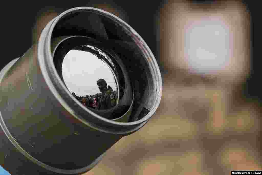 Reflektimi i një ushtari të FSK-së në tytën e një arme të ekspozuar për Ditën e Forcës. 