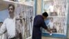 An Iraqi worker puts up a poster about reconciliation on a wall in Baghdad