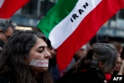 A demonstrator wears a sticker over her mouth with the words "no execution" prior to a silent march denouncing the Iranian government's deadly crackdown on anti-government protesters, on January 31 in Paris.