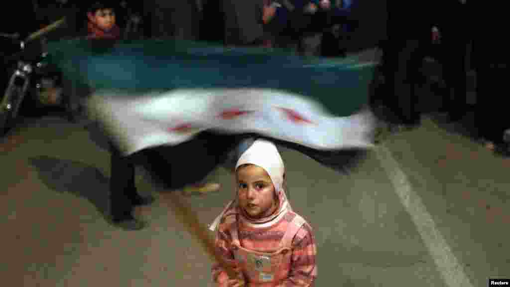 A girl waves a Syrian opposition flag during an antigovernment protest in Al-Qusayr on February 27. (Reuters/Goran Tomasevic)