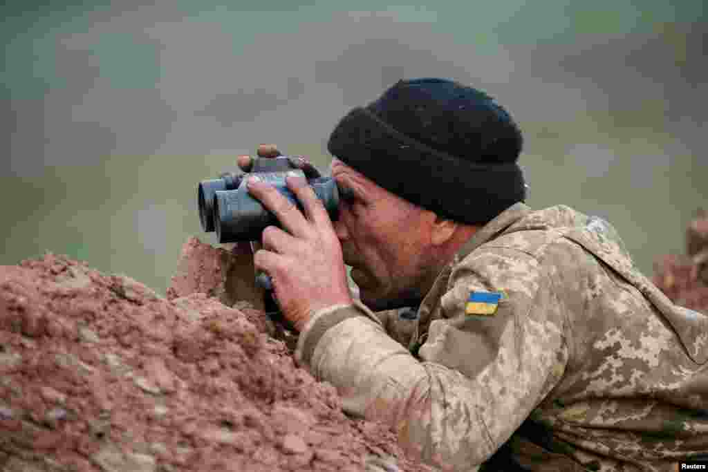 Український військовий спостерігає за активністю противника на передовій під Світлодарськом. Донецька область, квітень 2019