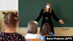 Egy tanárnő maszkban tartja az órát egy podgoricai iskolában.